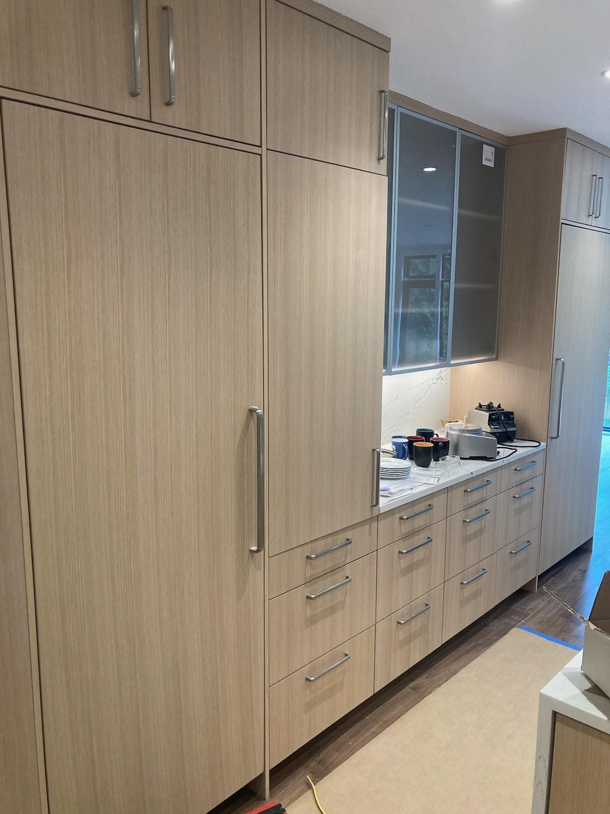 Custom floor-to-ceiling pantry cabinetry with light wood fronts and integrated storage