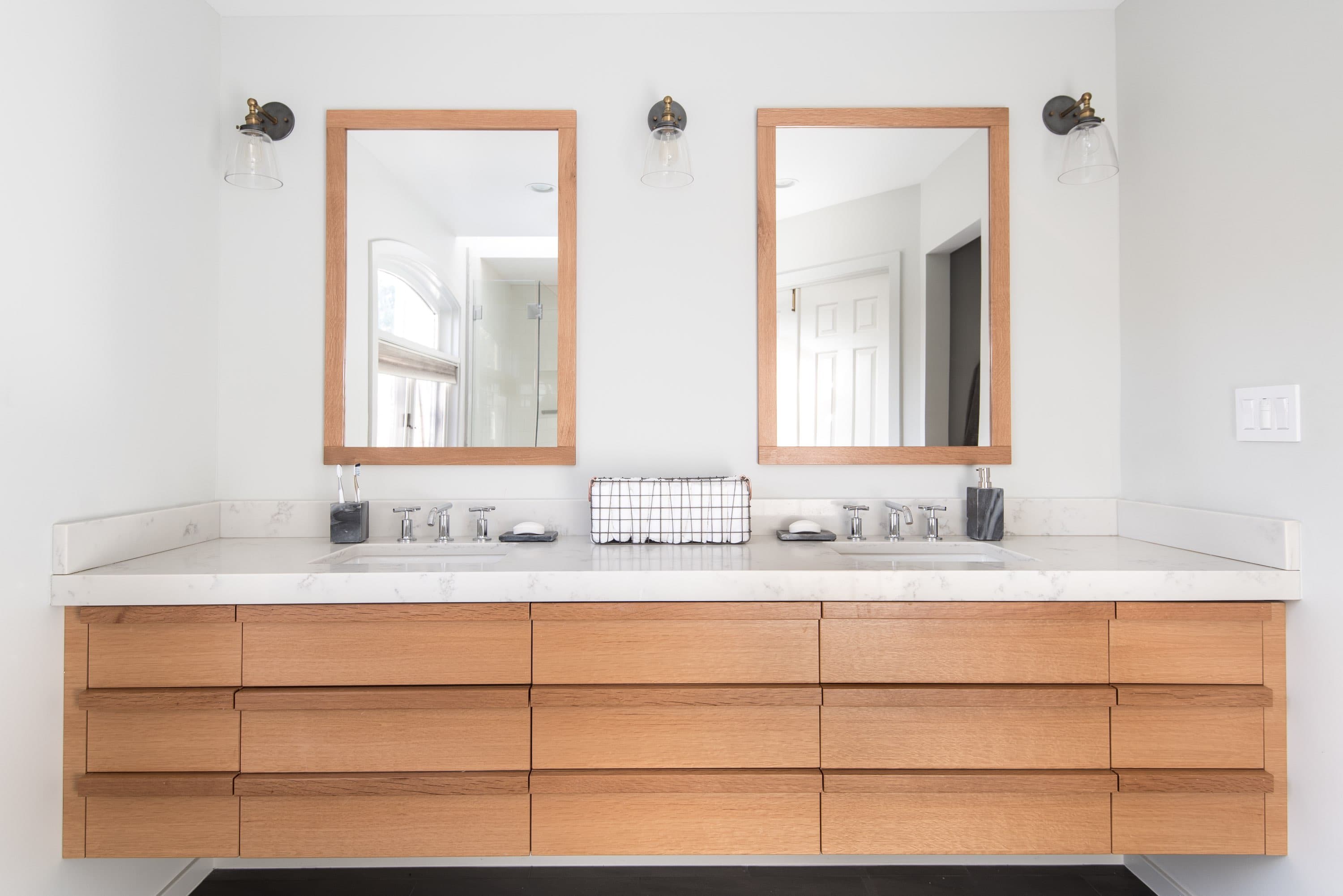 Custom double-sink bathroom vanity in warm wood with a marble countertop